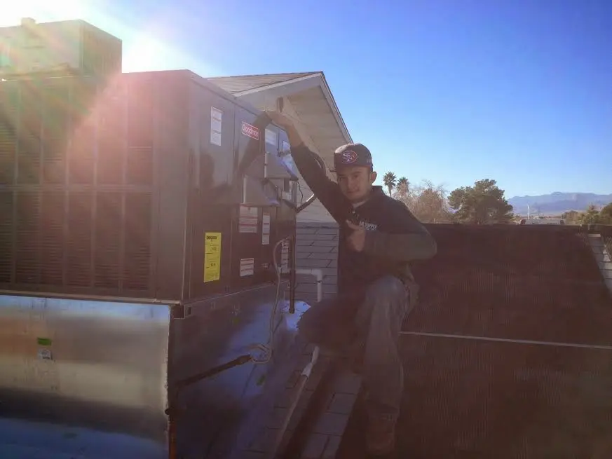 HVAC technician performing Air Duct Repair on a rooftop unit in Aberdeen